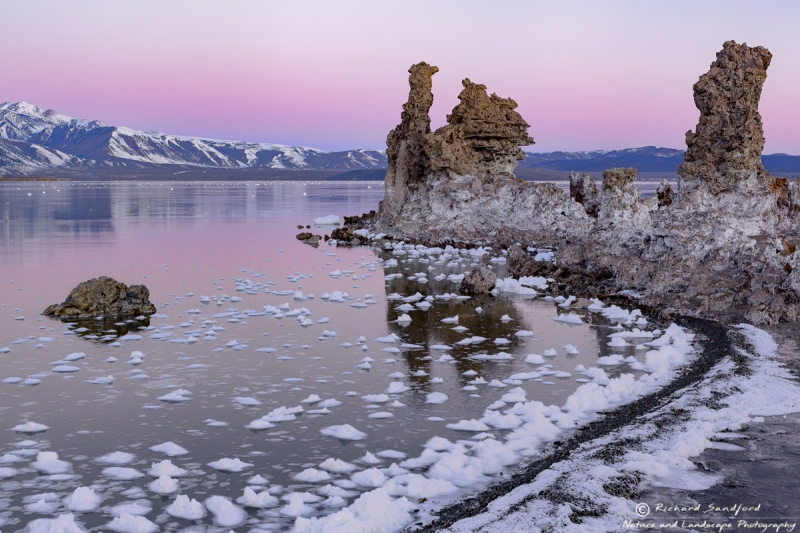 The snow covered Eastern Sierras and a vibrant sunrise provide a stunning backdrop for the magnificent tufas at Mono Lake, Lee Vining, California.